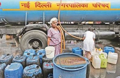 印度新德里地区今年夏天供水紧张。图为6月28日，人们从水车中接取饮用水。